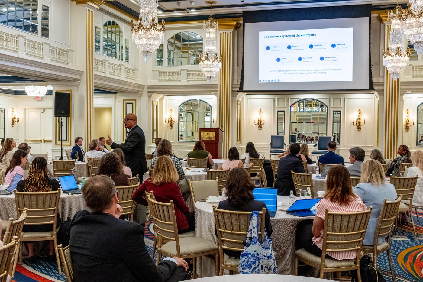 Ravi Teja Bommireddipalli mid-keynote at the Fisher Phillips AI Evolution conference, addressing a full ballroom beneath a slide reading 'Every revolution amplified something different.'